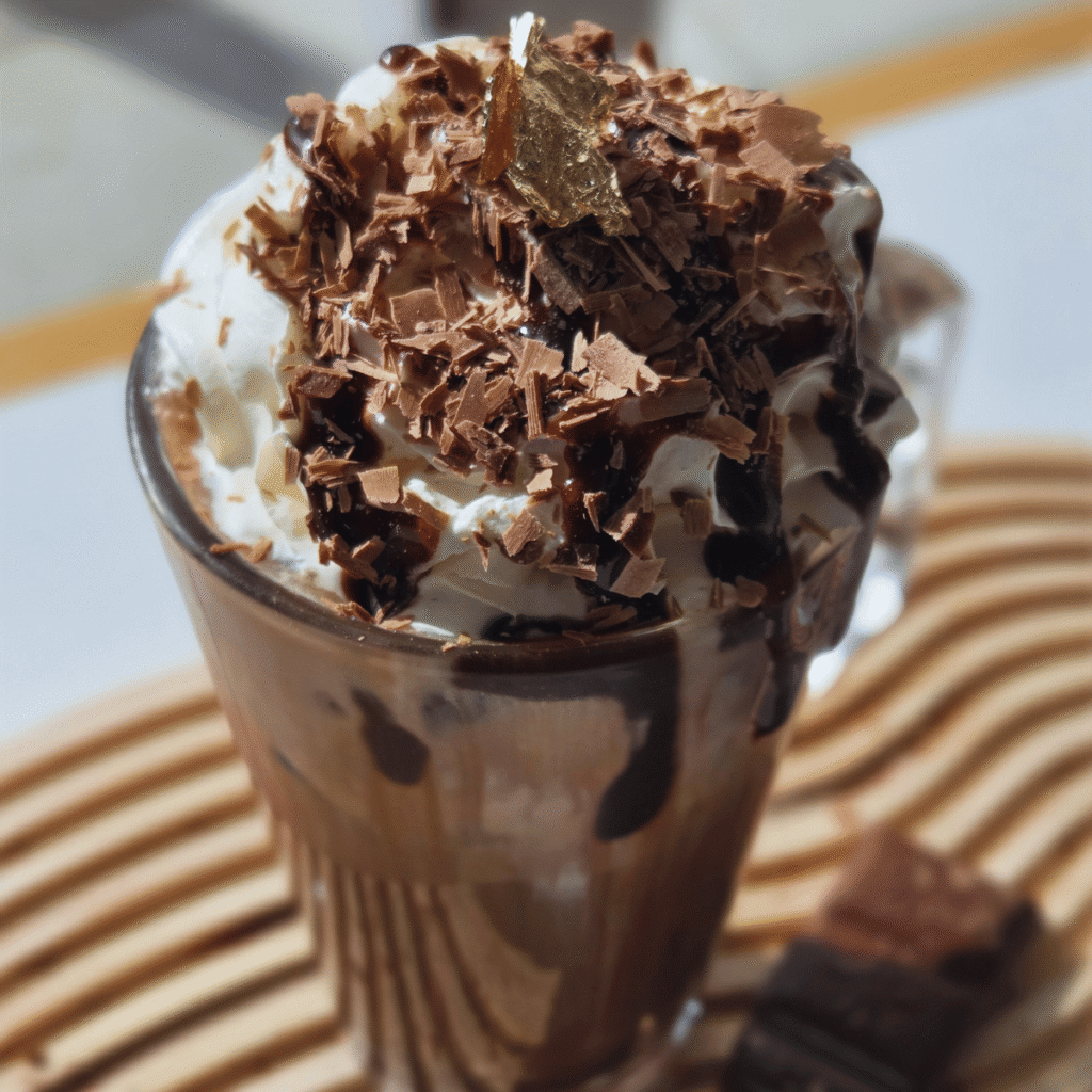 Iced Mocha topped with whipped cream, chocolate sauce and chocolate shavings