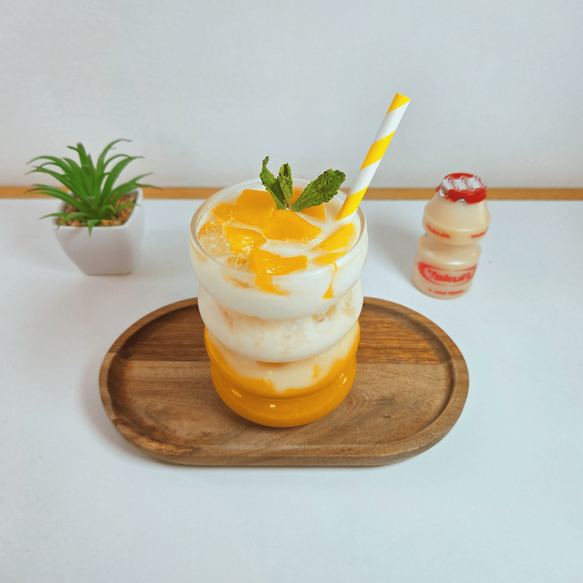 Mango Yakult Drink Garnished with Mango Slices and Mint Leaves