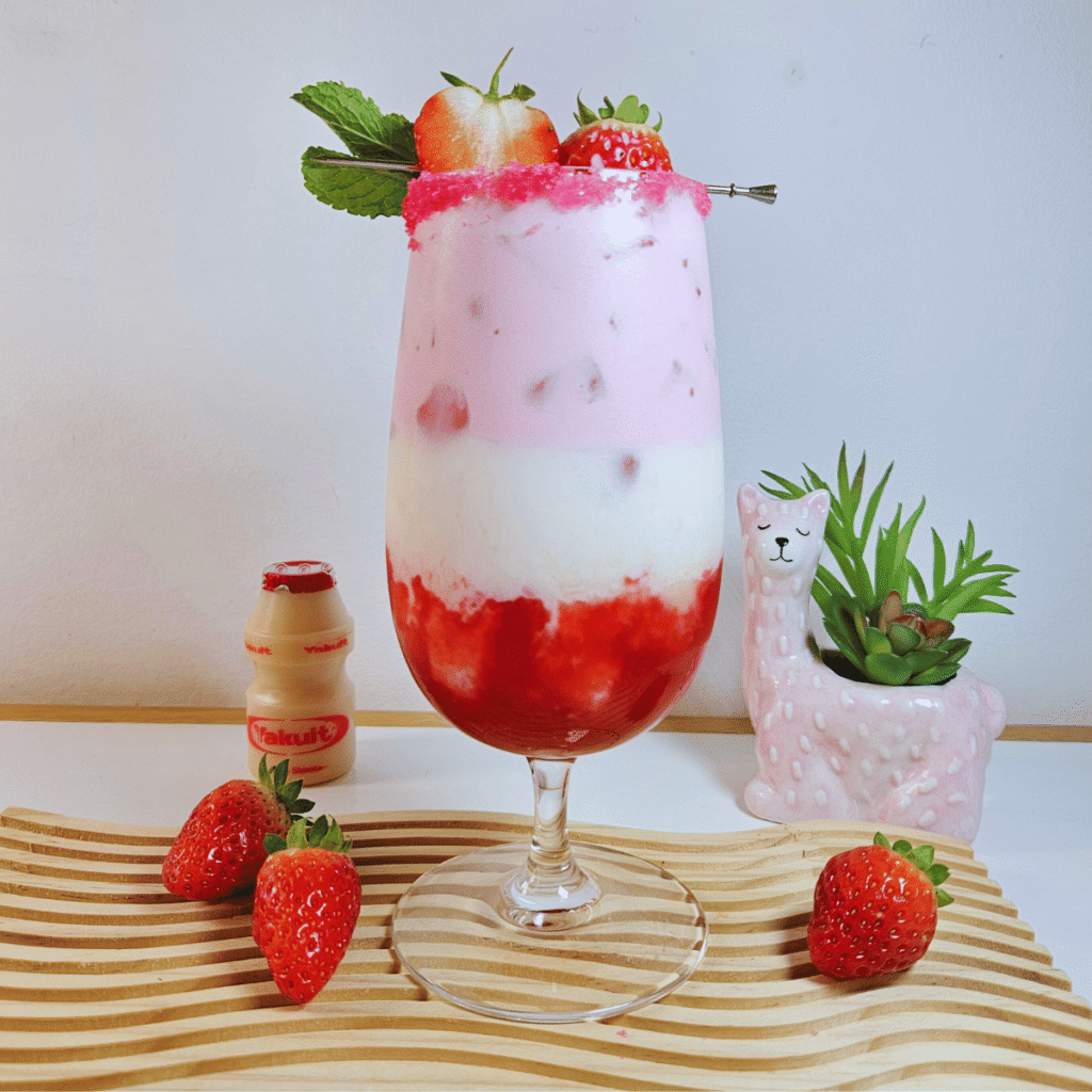 Layered Strawberry Yakult drink garnished with strawberries and mint leaves