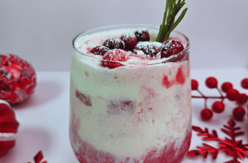 Cranberry Vanilla Swirl Mocktail garnished with cranberries and a sprig of rosemary